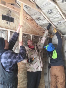 Mekasi, Matthew and Lyssa insulate a solar barn.